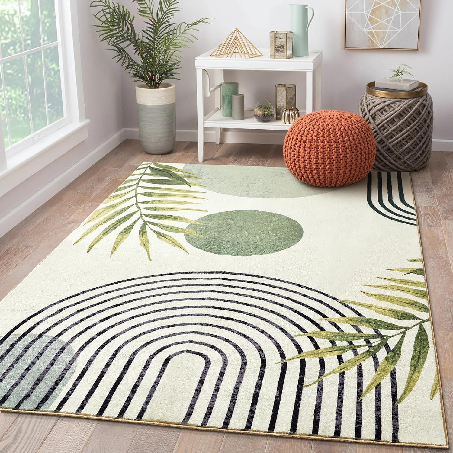 Boho-print 3x5 area rug with cream base, sage circles, and arched line patterns in a styled living room with a knit pouf