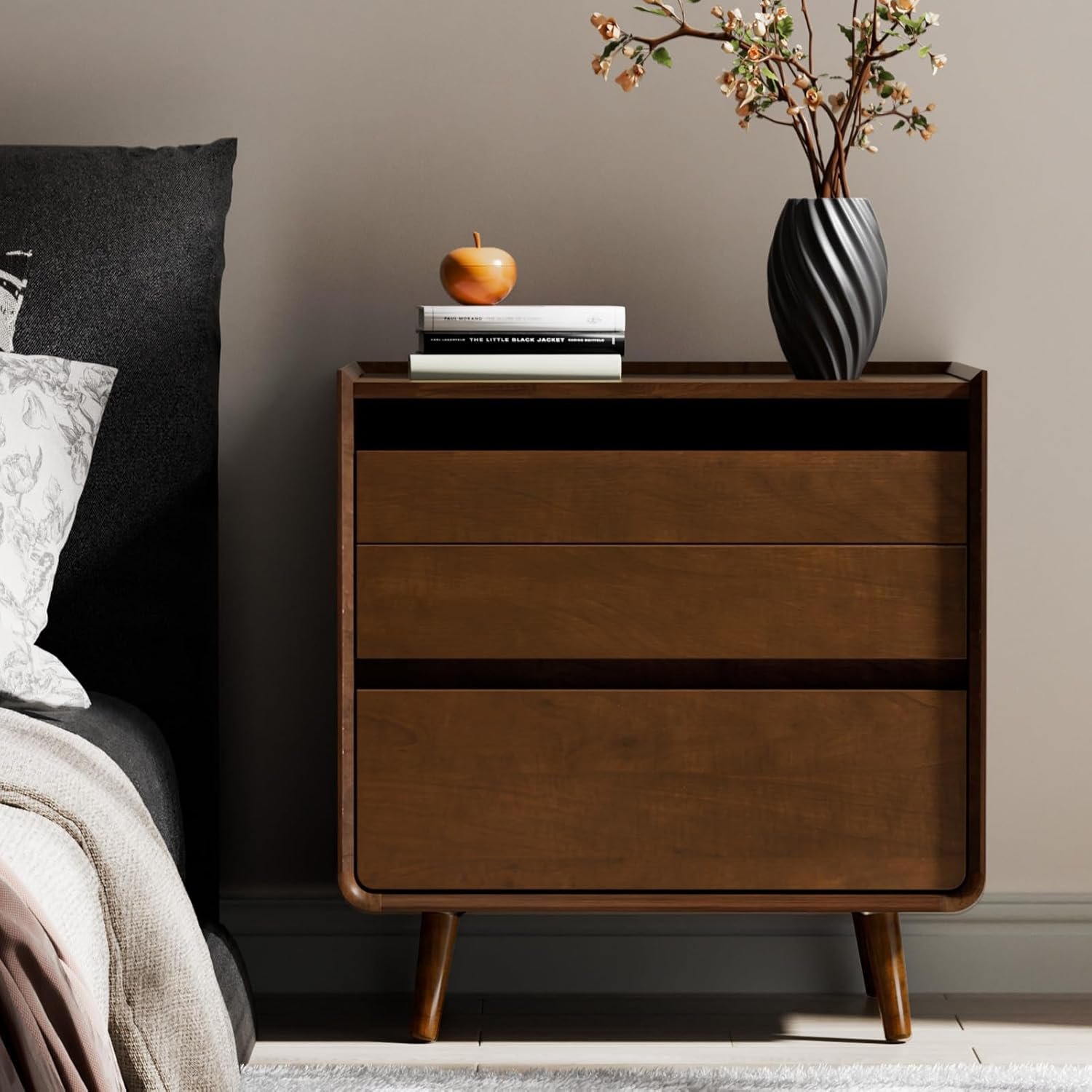 Walnut mid-century nightstand with open shelf and tapered legs in a cozy bedroom