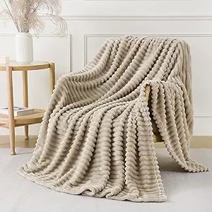 Khaki ribbed throw blanket draped over a couch in a warm cozy living room